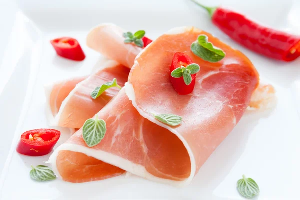 Ham with hot pepper and oregano leaves — Stock Photo, Image