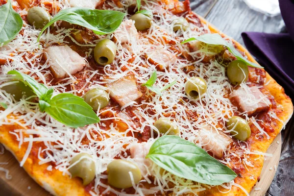Pizza grande com pedaços de bacon e azeitonas — Fotografia de Stock