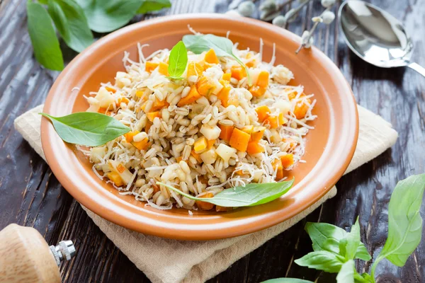 Barley porridge with chunks of carrot — Stock Photo, Image