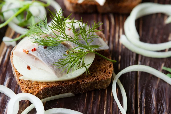 Canapes of black bread and salted herring — Stok Foto