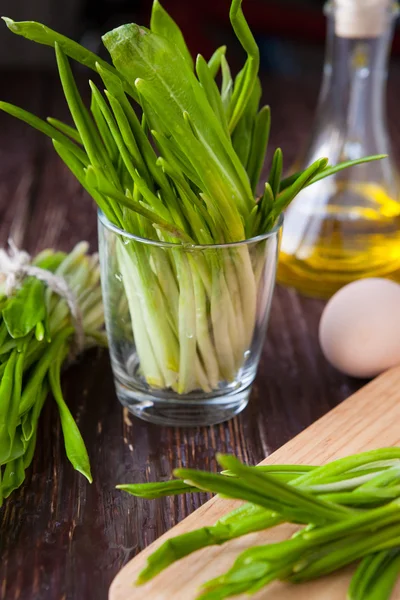 Bunch lush spring wild leek in a glass, — Stock Photo, Image