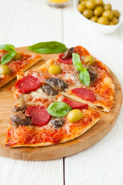 Pizza salami en kaas gesneden op een bord — Stockfoto