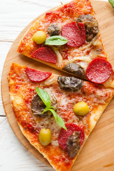 Zwei große Scheiben Pizza mit Käse, Champignons und Salami auf B — Stockfoto