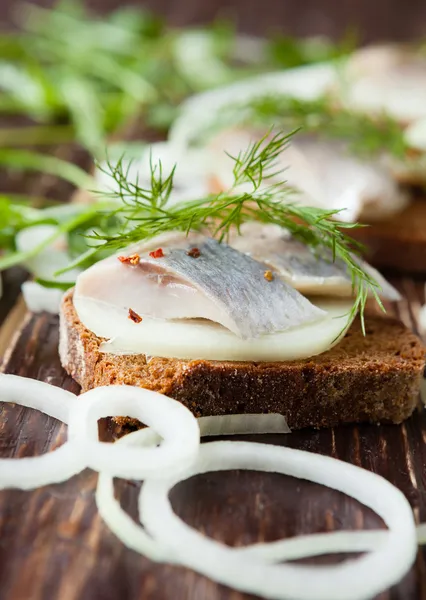 Filete de arenque sobre pan de centeno y aros de cebolla — Foto de Stock
