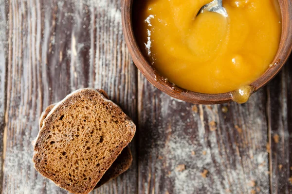 Buckwheat honey in a bowl and pieces of rye bread — Stock Photo, Image