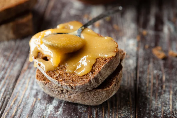 Gekonfijte gouden honing op volkoren brood — Stockfoto