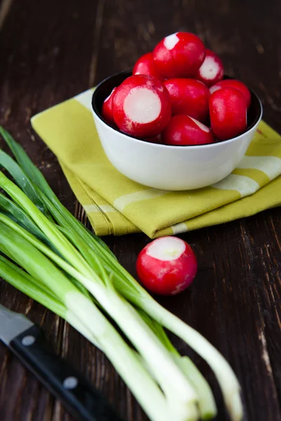 Radishes in a bowl and a bunch of green onions — Stock Photo, Image