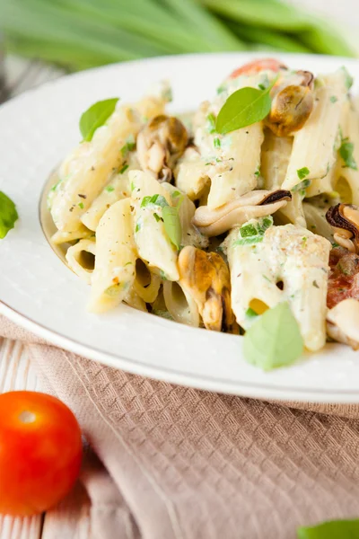 Penne pasta met mosselen en basilicum en room — Stockfoto