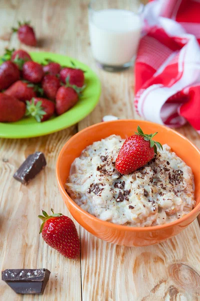 Oatmeal in a bowl with milk and strawberries, — Stock Photo, Image