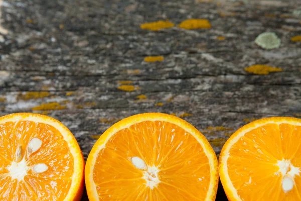 Fatias de laranja em uma superfície de madeira — Fotografia de Stock