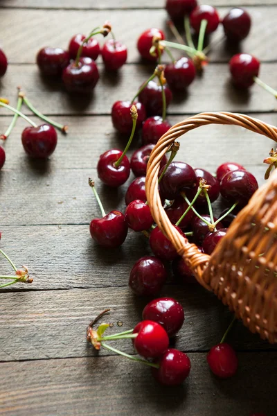 Ripe cherries in bulk on a table and a basket — Stock Photo, Image