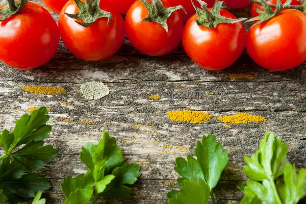 Tomates et herbes sur une vieille planche, fond — Photo