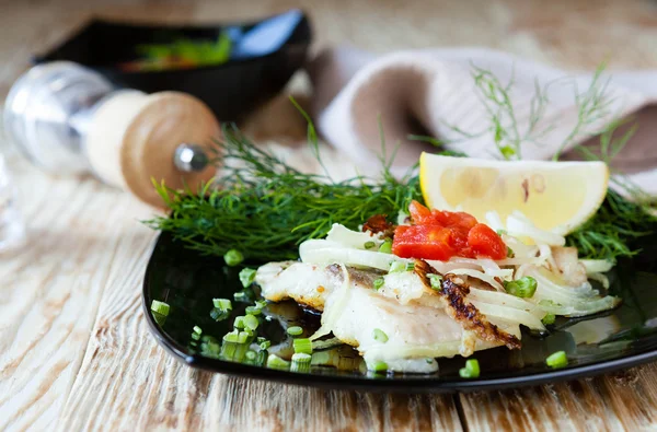 Fried fish on a black plate — Stock Photo, Image