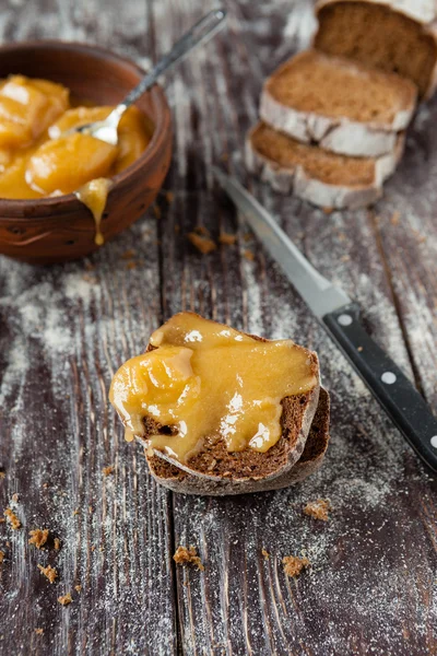 Pão e mel em uma mesa de madeira — Fotografia de Stock