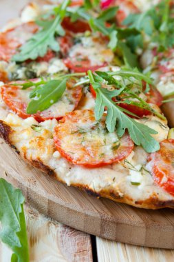 Domatesli pizza, peynir ve roka.