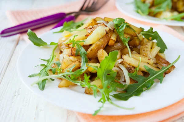 Fried potatoes with arugula