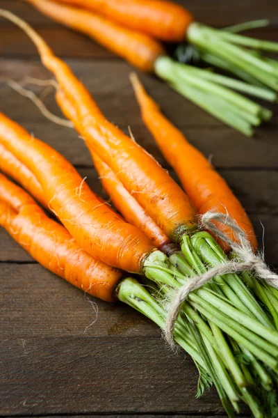 Paquet de bébé carottes sur des planches en bois — Photo