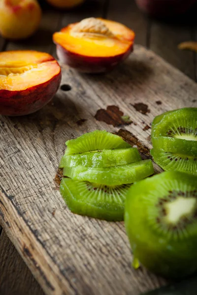 Fruta kiwi fatiada em uma tábua de corte — Fotografia de Stock