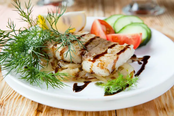 Peixe em um travesseiro com molho de cebola e verduras — Fotografia de Stock