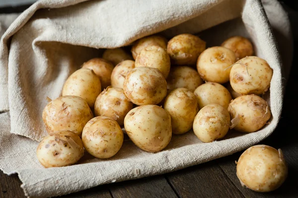 Yeni patates kabuğu tablosundaki bir torba ile — Stok fotoğraf