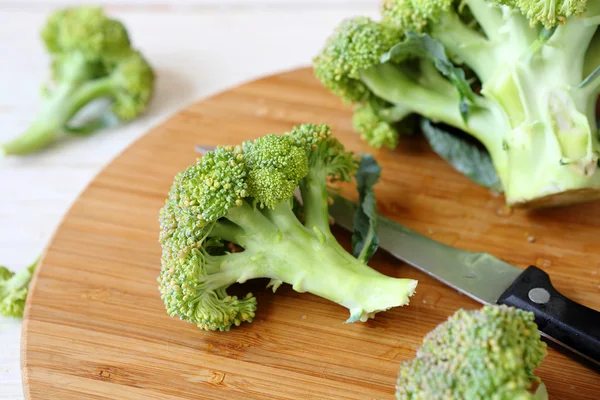 Färsk broccoli på en skärbräda och kniv — Stockfoto