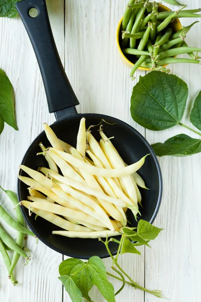 Green asparagus beans and a frying pan — Stock Photo, Image