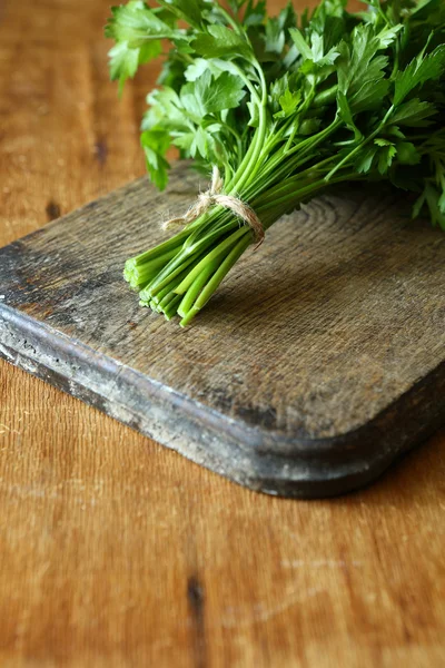 Fresh parsley on an old chopping board — Stock Photo, Image