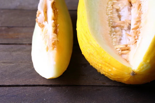 Delicioso melão amarelo em uma mesa de madeira — Fotografia de Stock