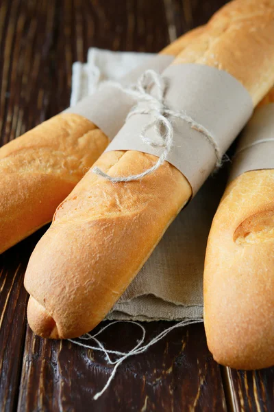 Baguettes crujientes y sabrosos en la mesa de madera — Foto de Stock