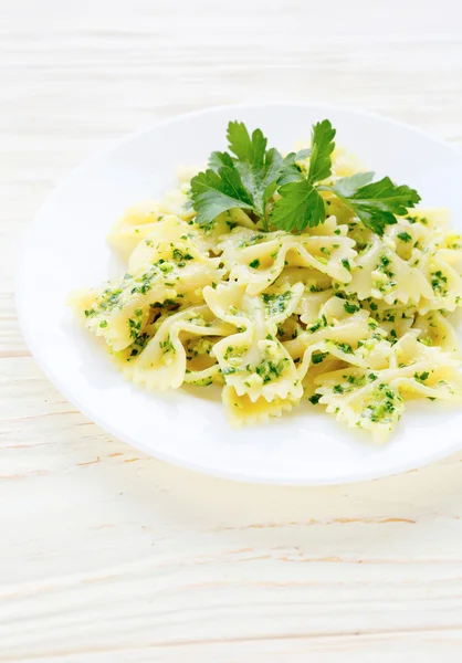 Farfalle pasta med pesto på vit platta — Stockfoto
