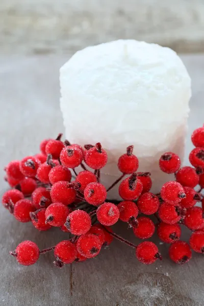 Weiße Weihnachtskerze und rote Beeren — Stockfoto