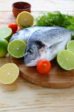 limon ve limes ile tahta üzerinde taze balık