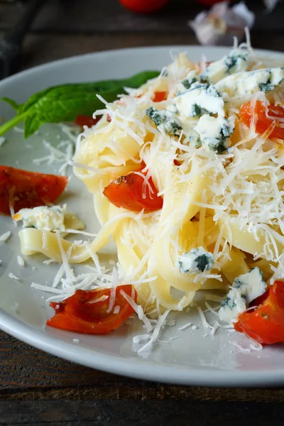 Pasta with grated cheese and tomatoes — Stock Photo, Image