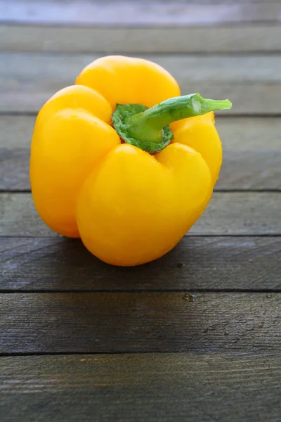 Round yellow pepper on wooden surface — Stock Photo, Image