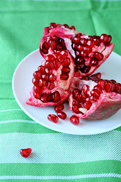 Fresh juicy red pomegranate on a saucer — Stock Photo, Image