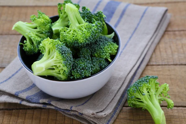 Färsk broccoli i en skål på ett rustikt bord — Stockfoto