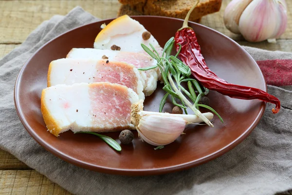 Kousky slaniny s kořením na talíři — Stock fotografie