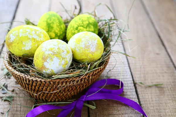 Easter egg in a basket with ribbon — Stock Photo, Image