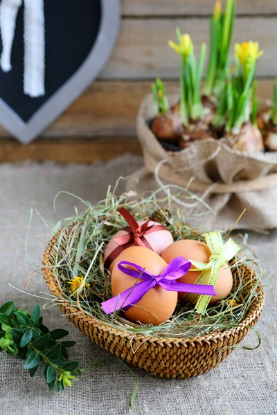 Osterstillleben mit Korb und Blumen — Stockfoto