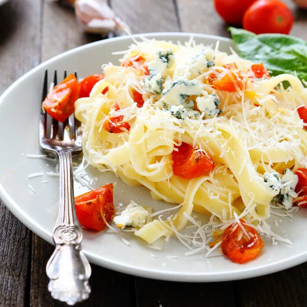 Pasta with grated parmesan cheese and tomatoes — Stock Photo, Image