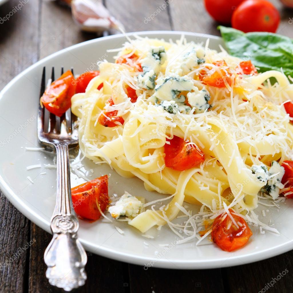 Pasta with grated parmesan cheese and tomatoes Stock Photo by
