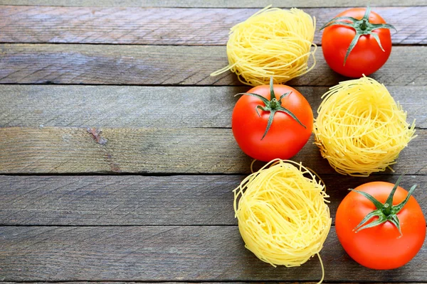 Сырые макароны и свежие помидоры — стоковое фото