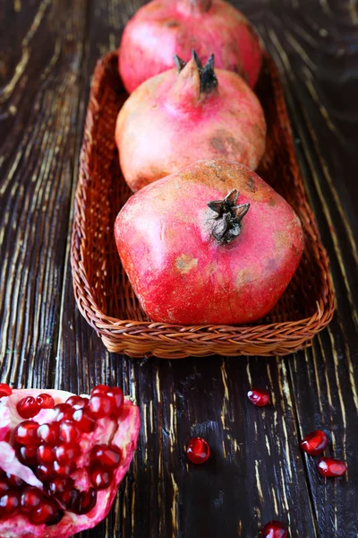 three pomegranate on a wicker tray