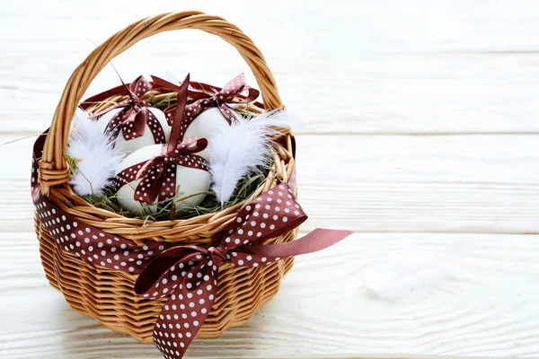 Easter eggs in a basket on white boards — Stock Photo, Image