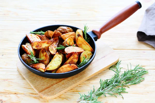 Potato wedges with rosemary in a pan — Stock Photo, Image