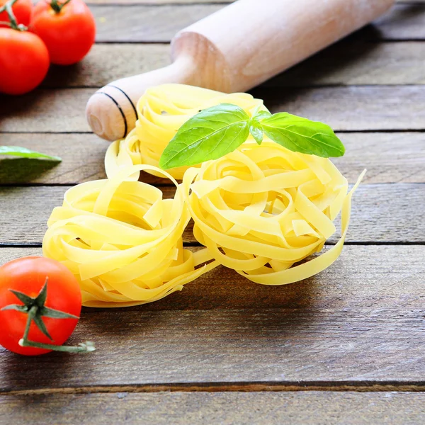 Pasta and rolling pin on the wooden background — Stock Photo, Image
