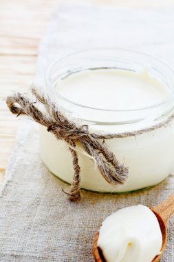 bir kavanoz ve tahta kaşık taze krema