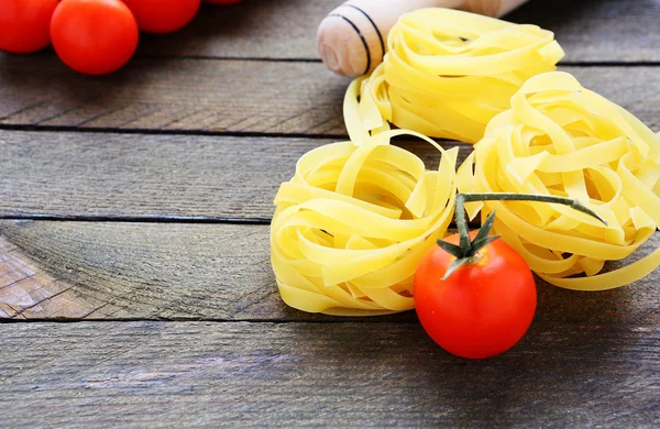Fresh tomatoes and pasta rolling pin — Stock Photo, Image