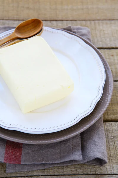 Blok van boter op een plaat — Stockfoto
