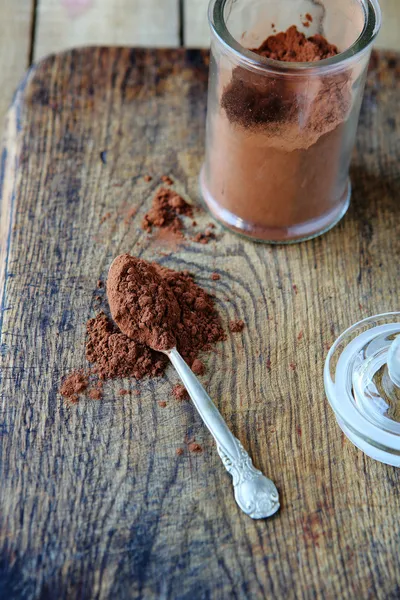 Cocoa powder on a spoon in a jar — Stock Photo, Image